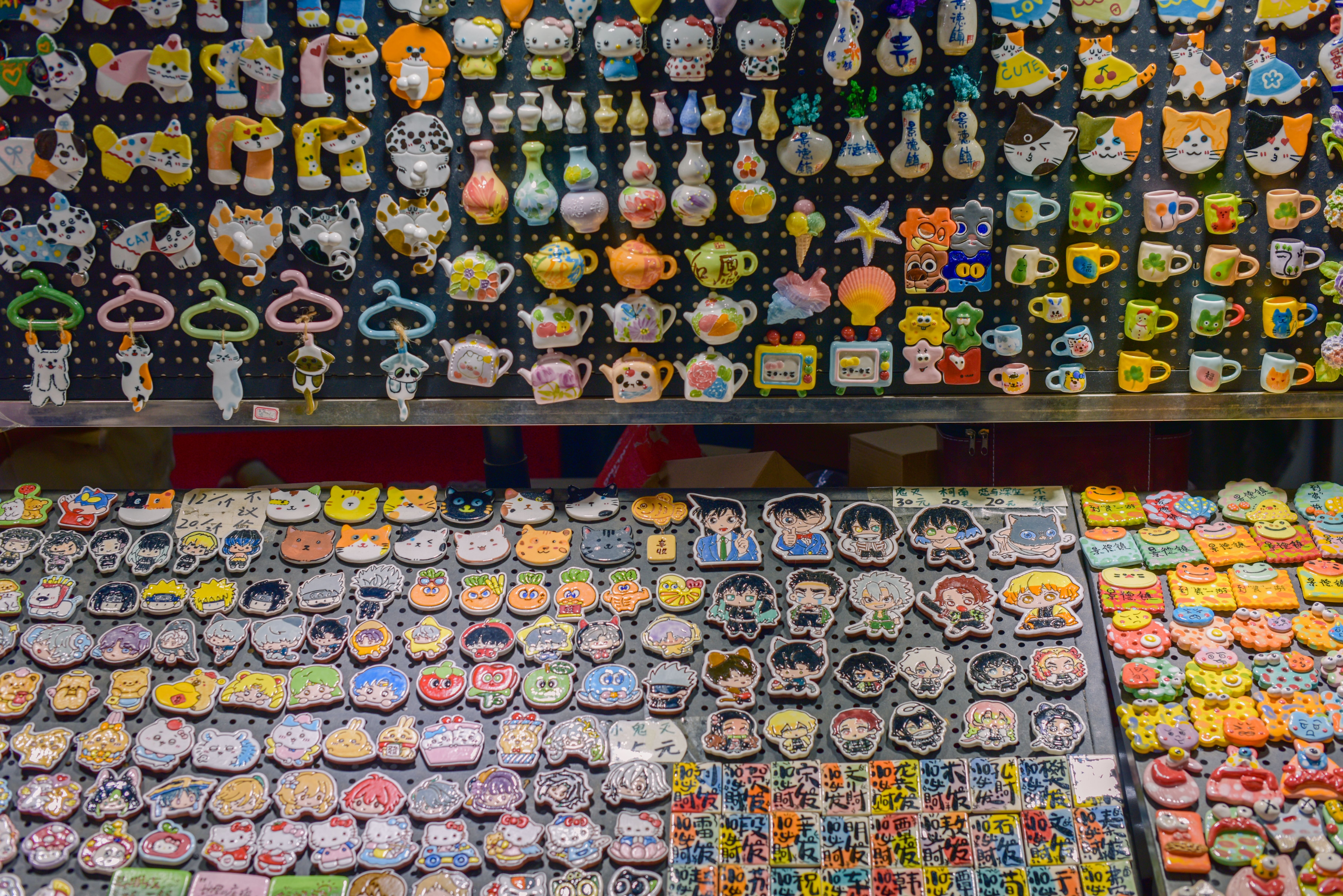 Aimant décoration chat : magnets chats variés exposés sur un étal de boutique, designs kawaii et artistiques pour frigo, décor félin maison.
